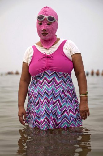 Une femme chinoise en facekini à la plage.