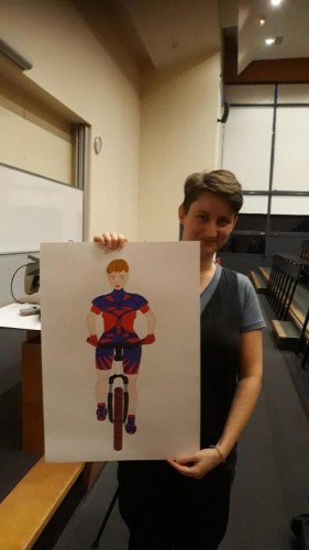 Marine Gilis tenant un dessin d'elle sur un vélo