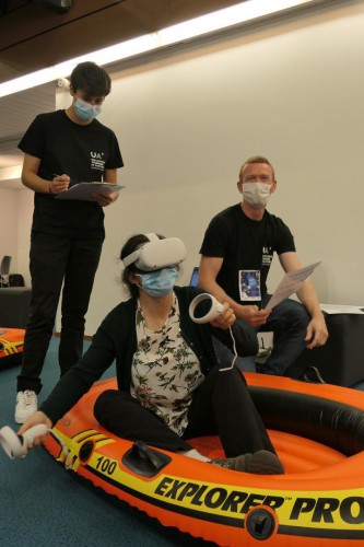 Le chercheur et doctorant Pierre-Henry Leveau accompagné d'une étudiante autour d'une utilisatrice de réalité virtuelle.